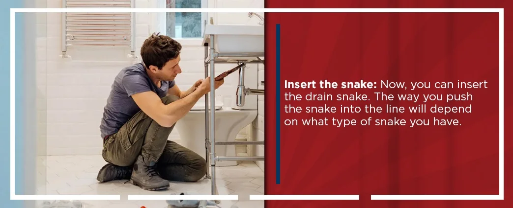 Plumber working on sink with text about snaking a drain