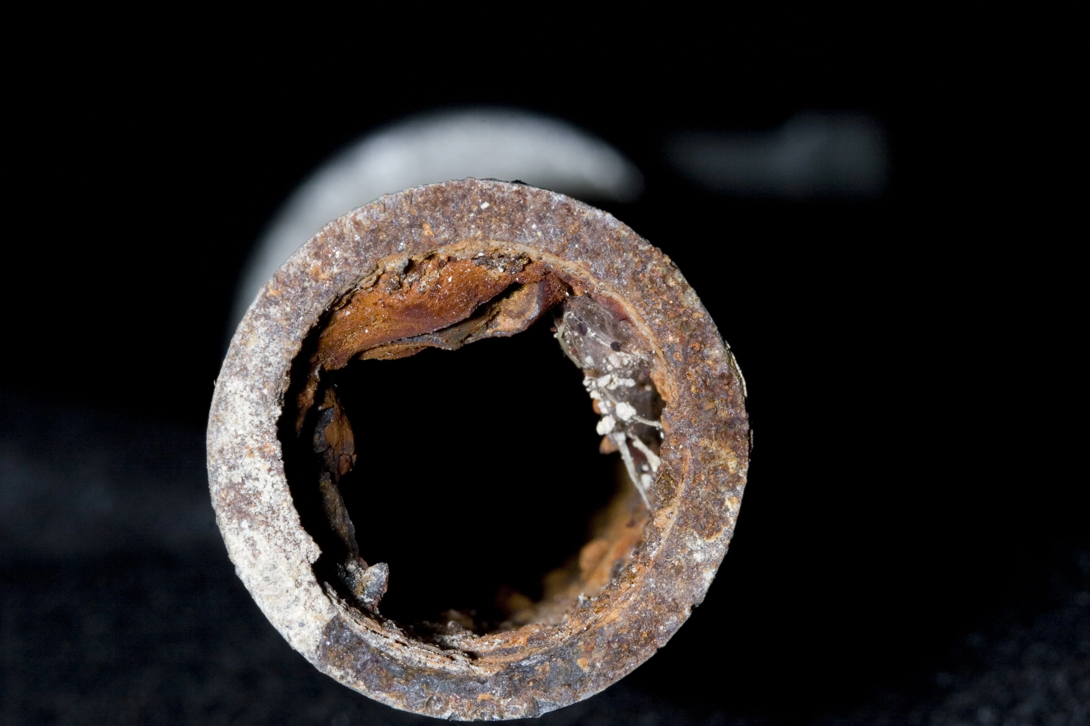A cross section cut of a rusty galvanized pipe that leads to clogged drains in older homes