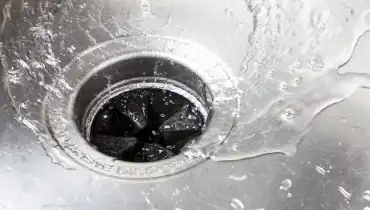 Water flows down a kitchen sink drain.