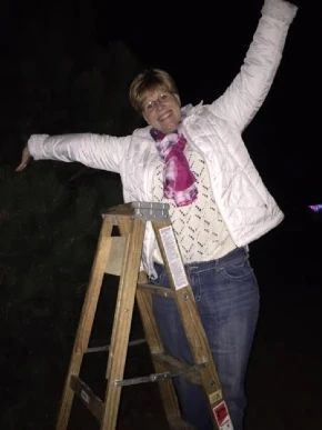 Happy lady on a ladder for Breast Cancer Awareness Month