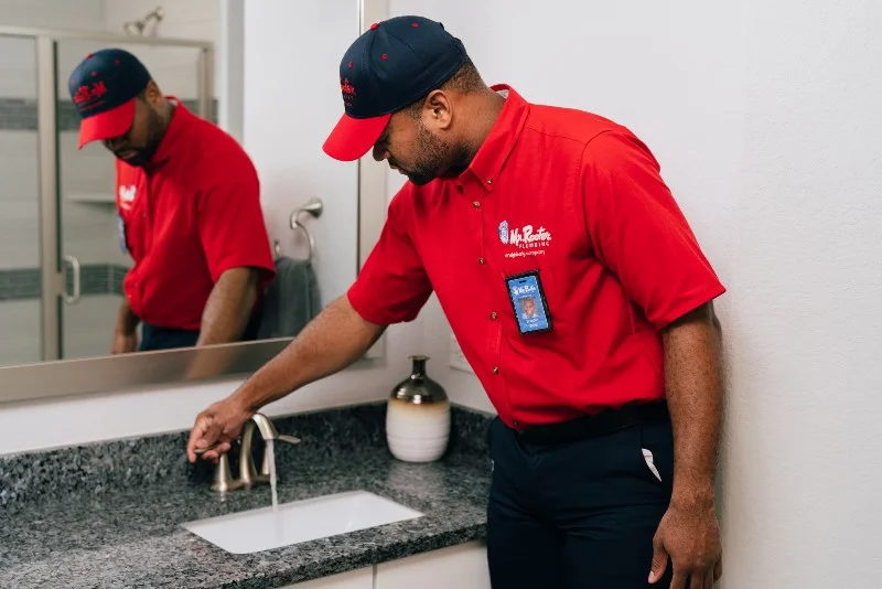 Mr. Rooter’s plumber runs water in the sink after drain cleaning.