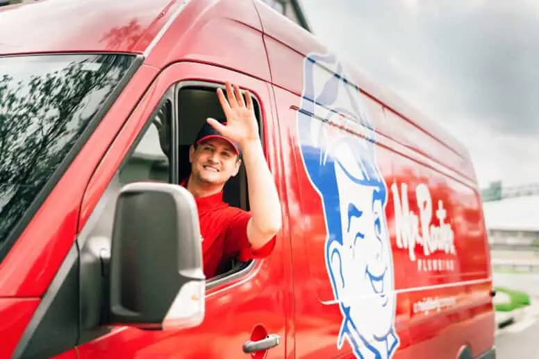 a Mr. Rooter plumber waiving from his work van