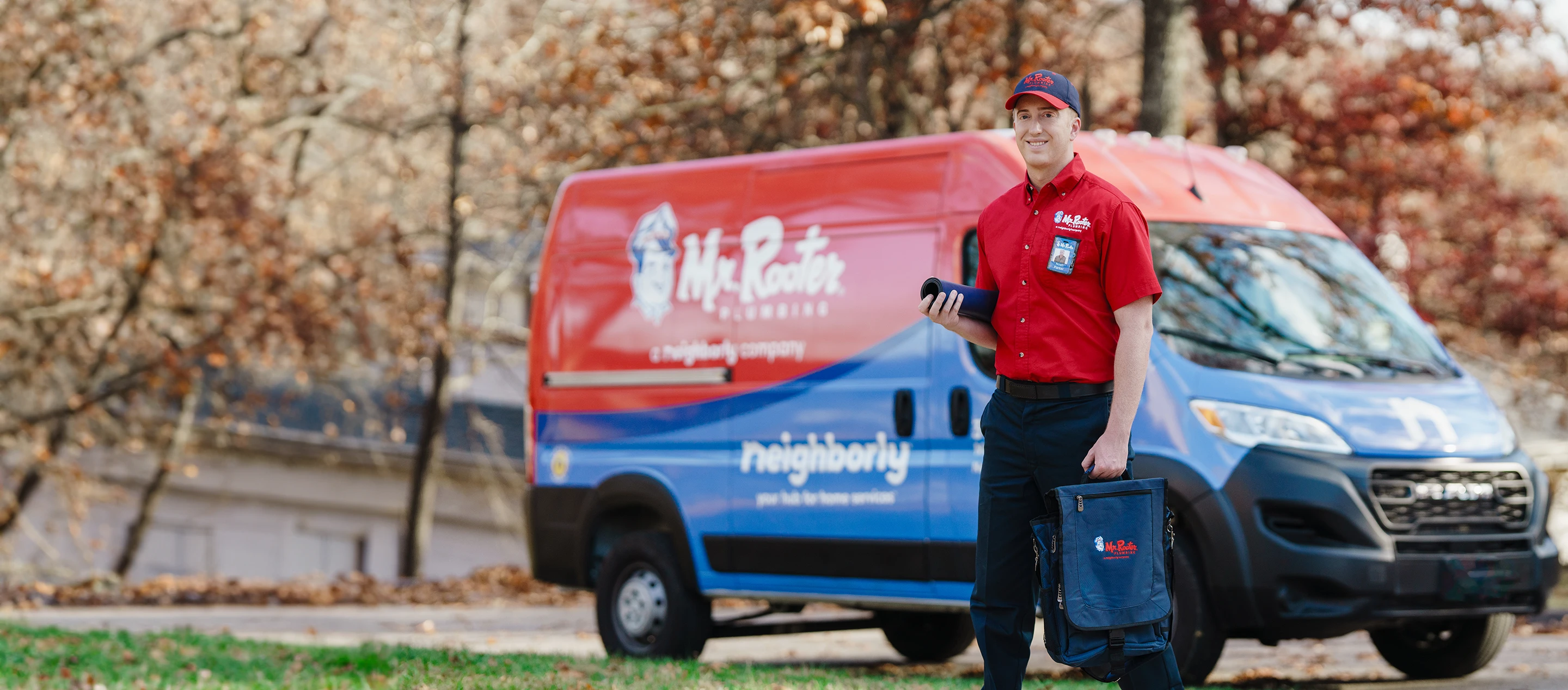 Mr. Rooter service professional standing beside a branded van.