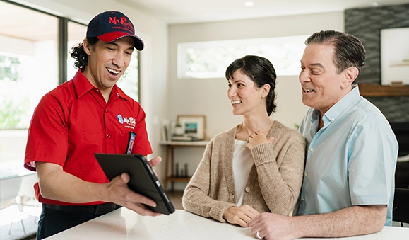 Mr. Rooter technician speaking with two customers.