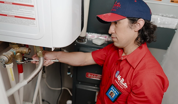 Mr. Rooter employee checking a water heater with a flash light.