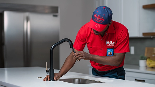 Mr. Rooter technician fixing a faucet.