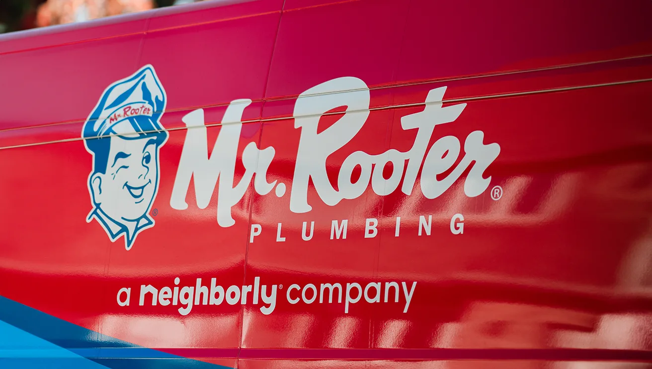 Close up view of a Mr. Rooter logo on the side of a work van.