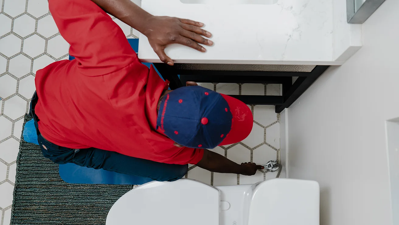 Mr. Rooter tehcnician fixing a toilet water valve.