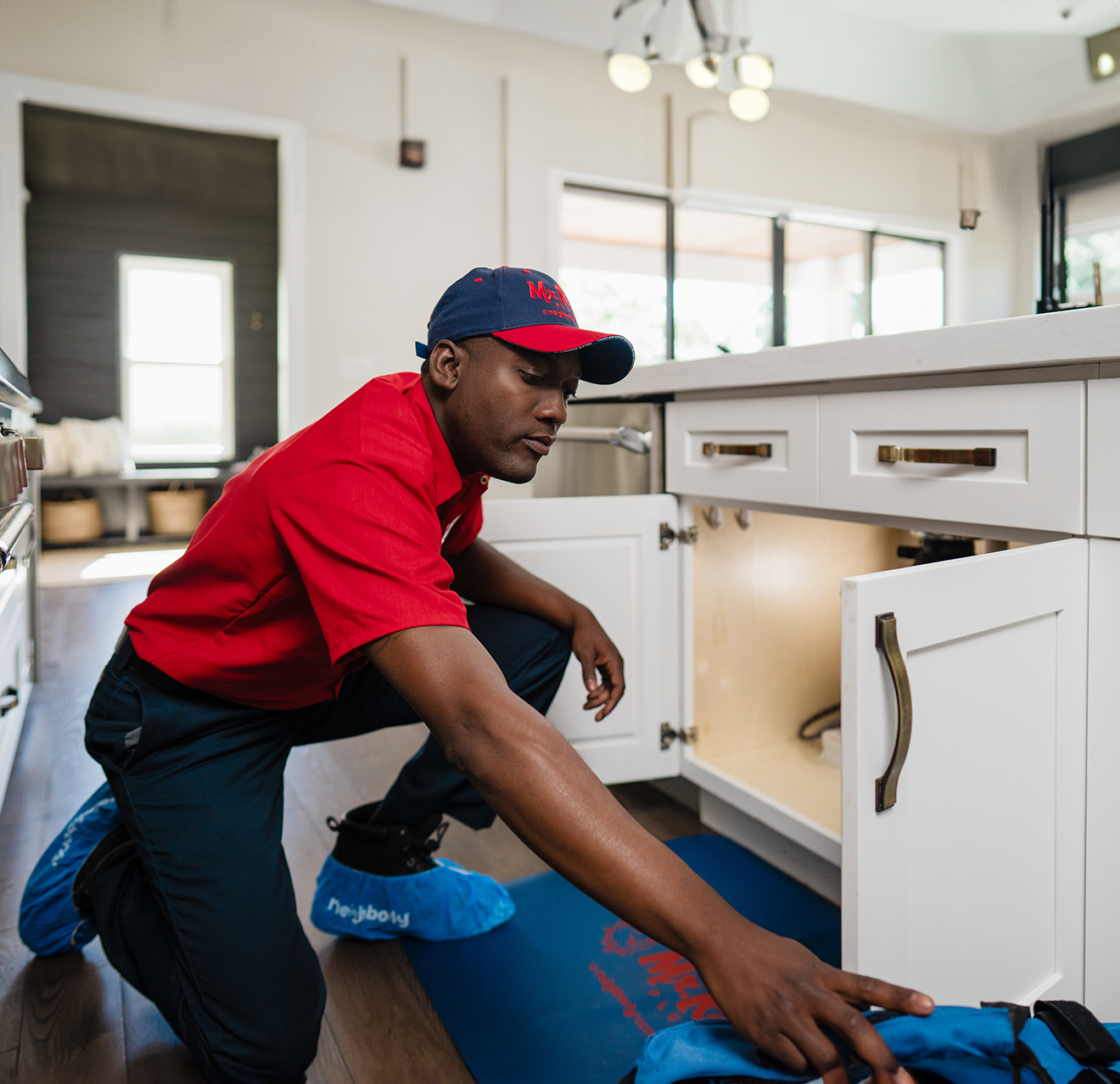 Mr. Rooter service technician repairing a garbage disposal.