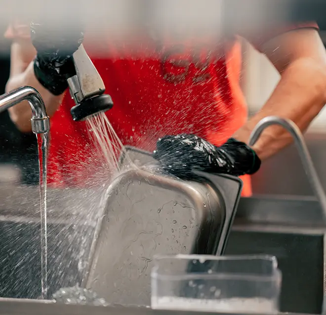 Mr. Rooter technician cleaning a grease trap.