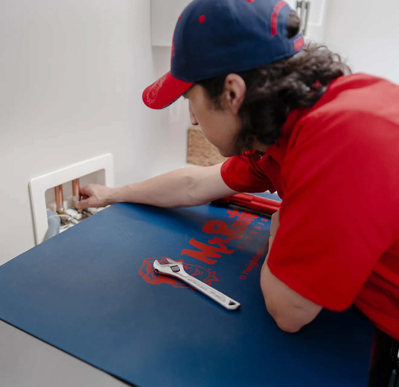 Mr. Rooter technician fixing a water valve.