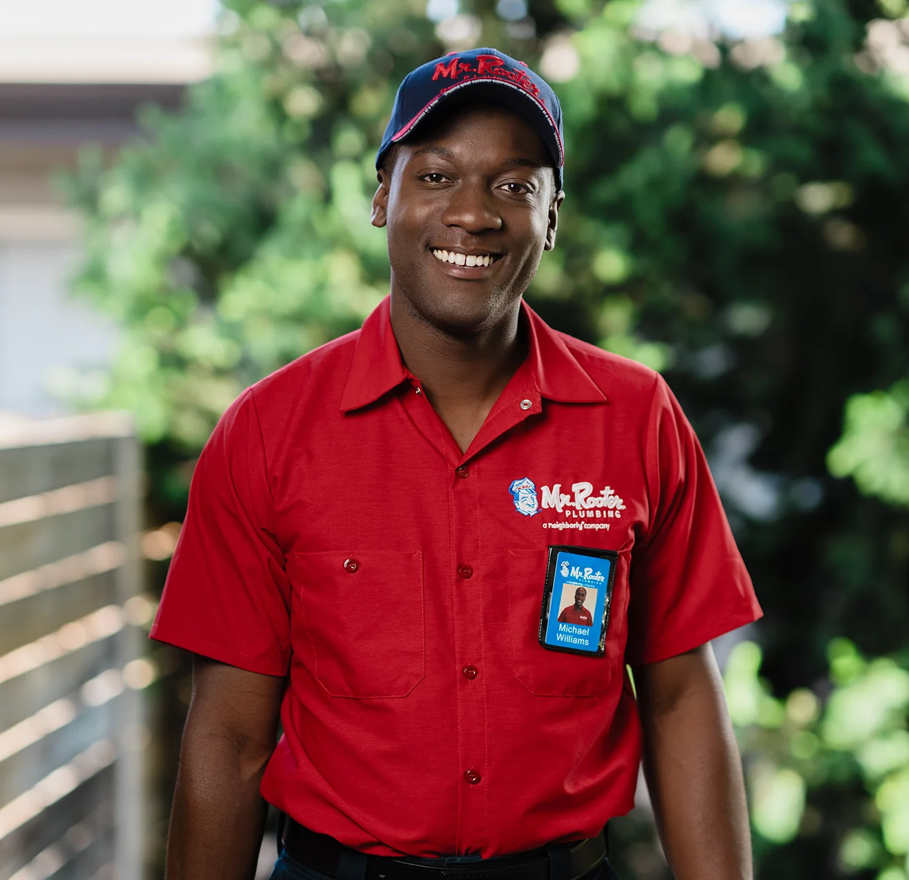 Portrait of a Mr. Rooter technician with greenery in the background.