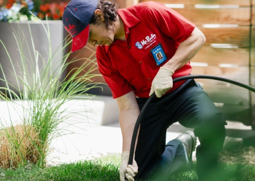 Mr. Rooter Plumbing service pro with a hose.