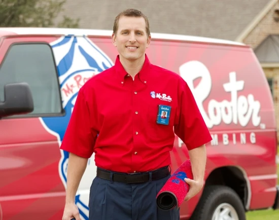 Mr. Rooter Technician walking up to the front door with protective mat.