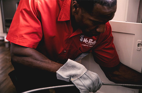 Mr. Rooter technician working under sink