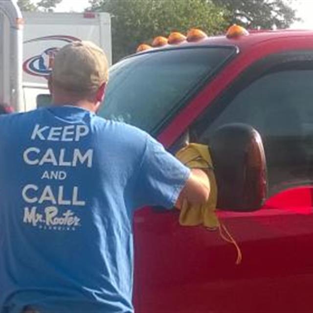 A Mr.Rooter employee cleaning the van.