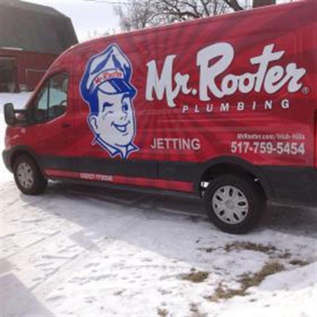 Mr rooter van parked in front of a house