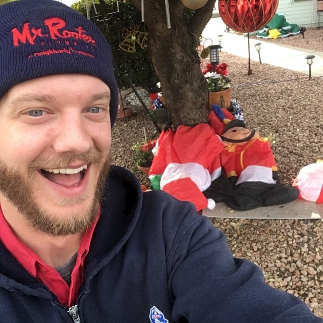 Mr. Rooter employee in front of holiday decorations