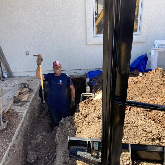 Mr. Rooter staff member standing in dirt smiling