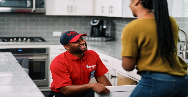 Mr. Rooter Plumbing technician, going over plumbing maintenance services with a homeowner.