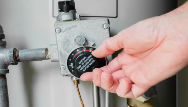 Plumber adjusting the temperature on a water heater.