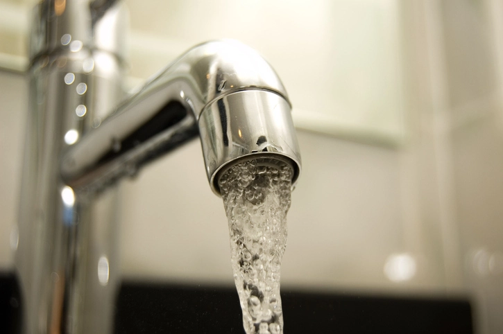 Close-up of water coming from a stainless steel faucet. | Mr. Rooter Plumbing of Yavapai, Coconino and Maricopa Counties