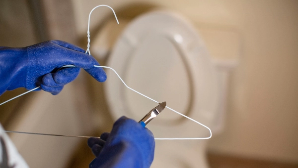 Person cutting a coat hanger