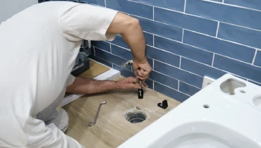 Plumber installing a toilet flange.