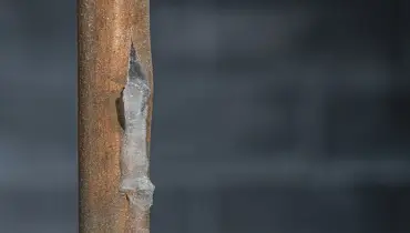 A close-up of a frosty copper pipe that has split from the frozen water inside | Mr. Rooter Plumbing of South Jersey