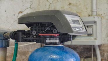 A close-up photograph of the timer and valve assembly of a water conditioner / water softener.