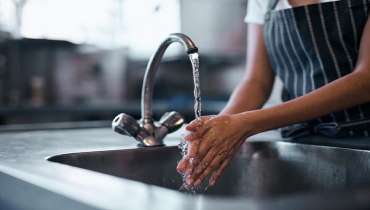 Woman washing her hands in the sink of a commercial kitchen | Mr. Rooter Plumbing of Southeast Georgia