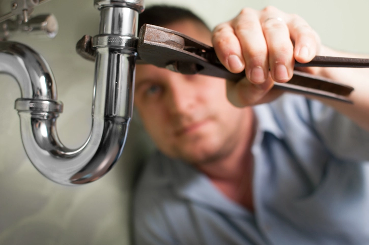 Plumber doing some work under the sink. Tightening siphon. | Mr. Rooter Plumbing of Yavapai, Coconino, and Maricopa Counties