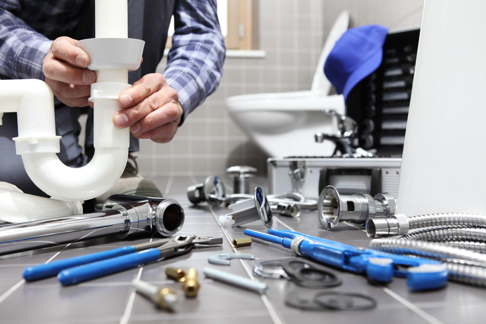 plumber at work in a bathroom, plumbing repair service, assemble and install concept.