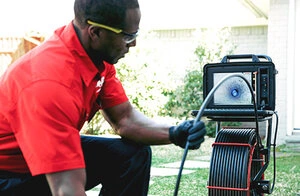 Mr. Rooter plumber using a plumbing video camera