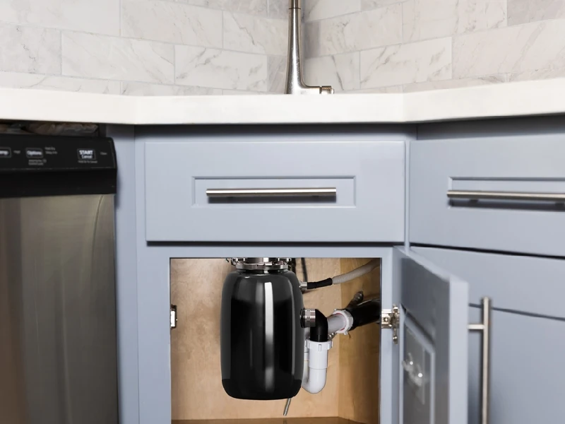 Garbage disposer installed under the sink in the kitchen.