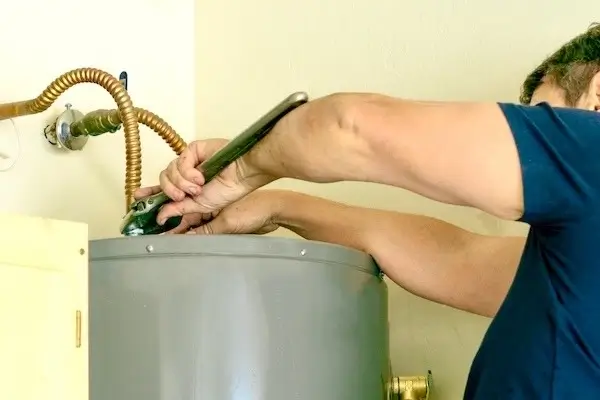 Plumber makes adjustments to new water heater