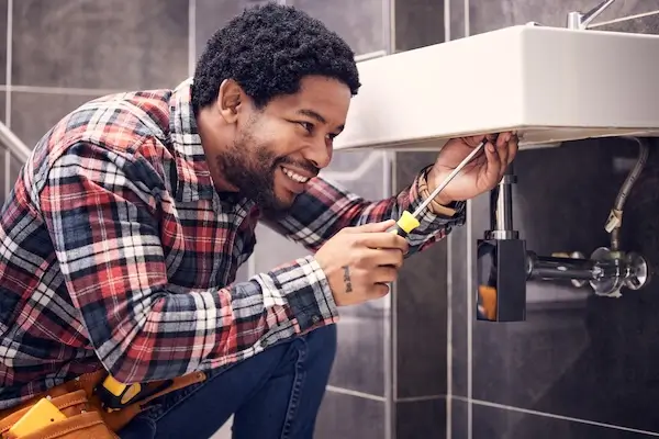  A plumber installing a new vanity as part of a bathroom remodel. 