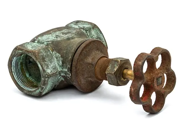 An old, rusty, and corroded main water shut-off valve