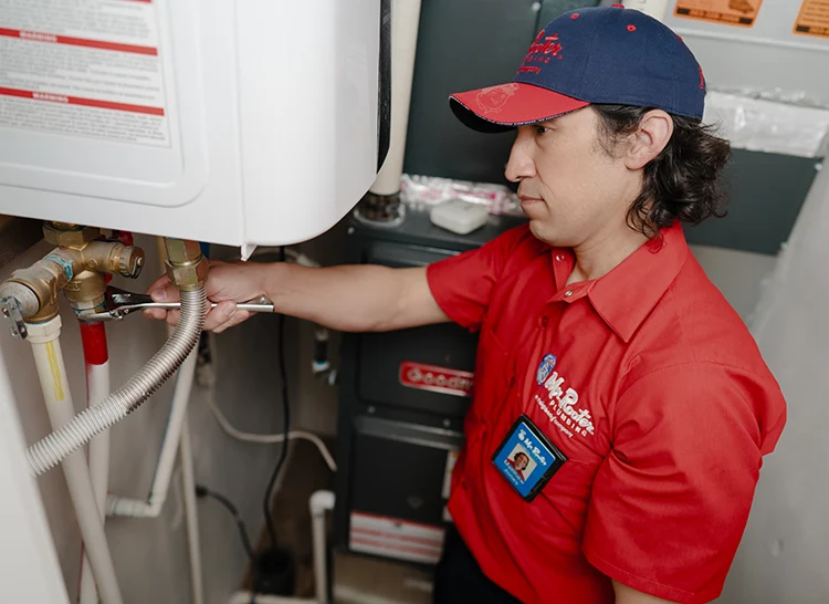 Mr. Rooter plumber installing a tankless water heater in Denver, CO